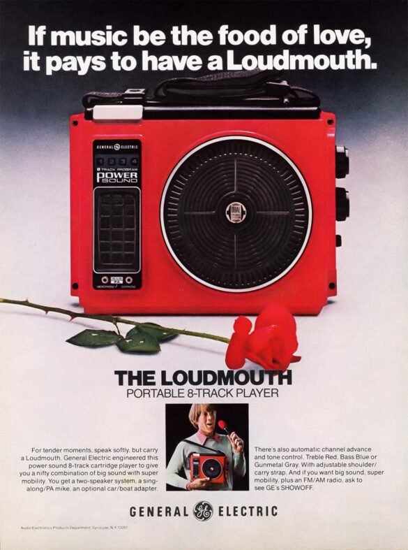 Vintage General Electric advertisement featuring a bright red Loudmouth portable 8-track player with shoulder strap, microphone and red rose.