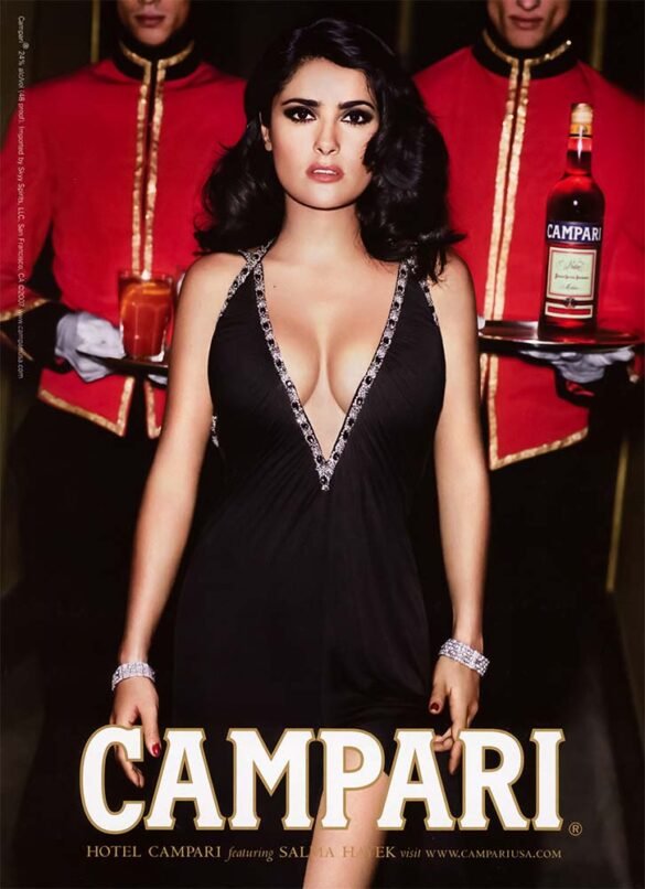 Salma Hayek for Campari in 2007, photographed as part of the brand’s Hotel Campari campaign. The ad mixes fashion-editorial glamour with the brand’s signature red palette, turning a liquor promotion into something that feels almost like a cinematic hotel scene.